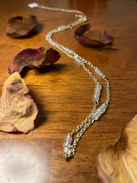 a necklace with rose petals on top of it