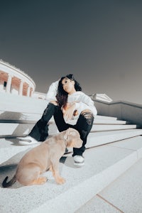 a woman sitting on steps with a dog