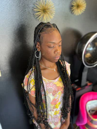 a young woman with long braids in a salon