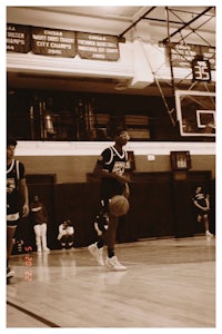 a man is playing basketball in a gym