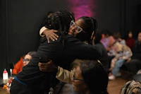 two people hugging in front of a crowd