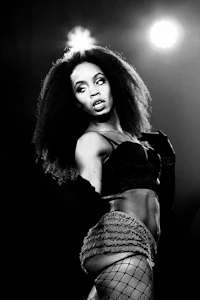 a black and white photo of a woman in fishnets