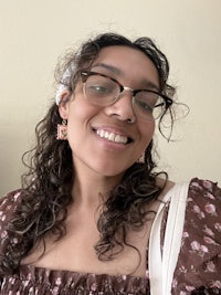 a woman wearing glasses and a floral top