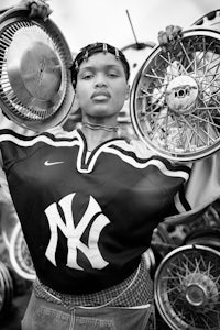 a black and white photo of a woman holding a yankees jersey