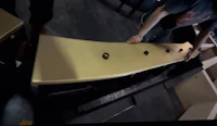 a man is working on a gold table in a warehouse