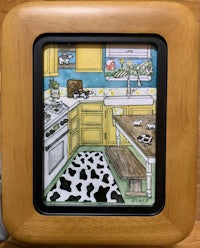 a wooden frame with a picture of a kitchen with cows on it