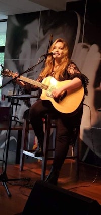 image may contain person, on stage, playing a musical instrument and indoor