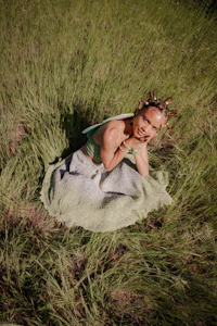 a woman in a green dress sitting in a field