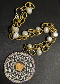 a necklace with a gold chain and a pendant with pearls