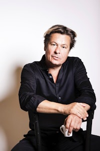 a man in a black shirt sitting on a chair