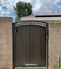 a wooden gate in front of a house with solar panels
