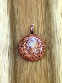 a copper pendant with a skull on it