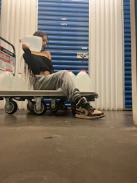 a woman sitting on a cart with a bottle of water