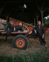 two women posing in front of an old tractor
