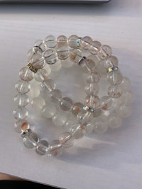 two bracelets with clear crystal beads on a table