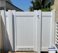 a white fence with a sign on it