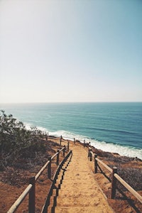 a path leading to the ocean on a hill