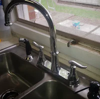 a kitchen sink with a faucet and a window