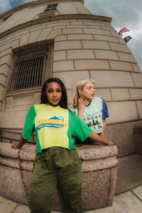 two women posing in front of a building