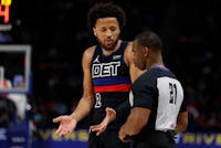 a basketball player is talking to a referee during a game