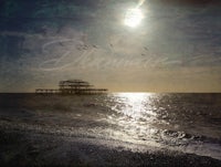 an image of a pier with birds flying over it