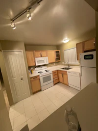 an image of a kitchen with white cabinets and appliances