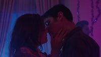 a man and woman kissing in a dark room