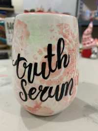 a wine glass with the words truth serum on it