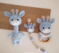 a blue crocheted giraffe with a wooden ring