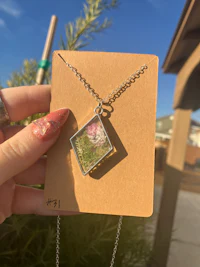 a person holding up a card with a flower in it