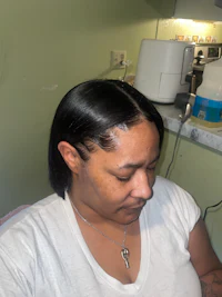 a woman is sitting in a chair with her hair cut