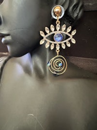 a mannequin wearing a pair of earrings with an evil eye