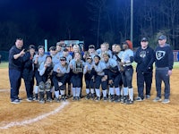 the softball team is posing for a picture on the field