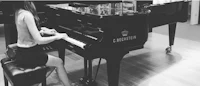 a woman is playing a piano in a room