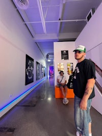 a man in a hat is standing in an art gallery