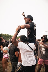 a man is being carried by another man at a music festival