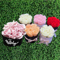 a bunch of roses in a black box with a birthday message
