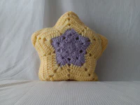 a yellow and purple crocheted star pillow
