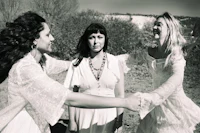 black and white photo of three women in white dresses