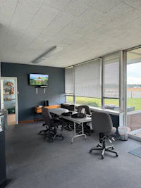 an office with several desks and a tv