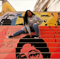 a woman sitting on a set of colorful stairs
