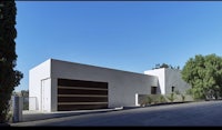 a white house with a garage on the side of the street