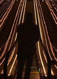 a man standing on an escalator at night