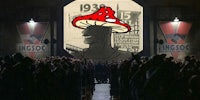 a man in a mushroom hat is standing in front of a crowd