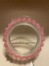 a pink bead ring on a white surface