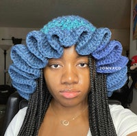 a woman wearing a crocheted ruffled hat