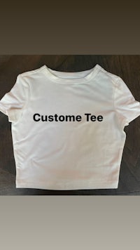a white crop top that says custom tee