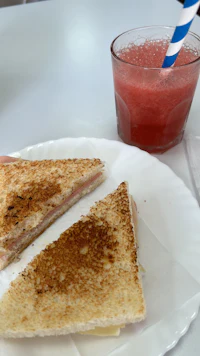 a plate with a sandwich and a drink on it
