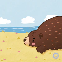 a brown bear laying in the sand