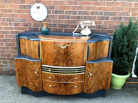a wooden sideboard with drawers in front of a brick wall